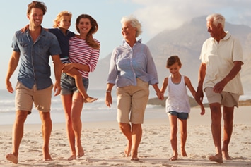 Happy family enjoying time together on a beach -CDCP dentist Toronto offers care covered by the Canadian Dental Care Plan for seniors, adults, and kids